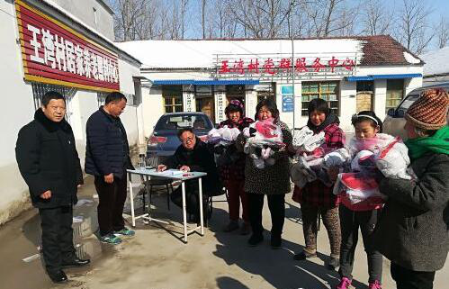 市妇联资助王湾村310 套衣服、鞋子，发放到贫困户手中