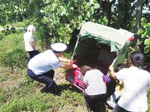 三轮车深陷水沟 热心警民伸援手